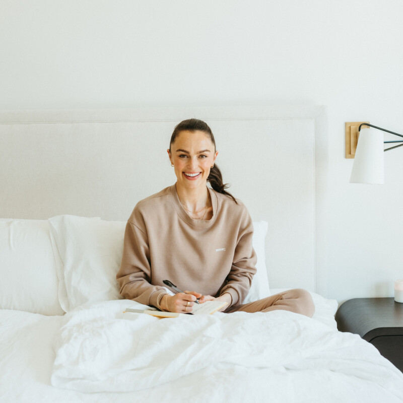 Woman journaling in bed.